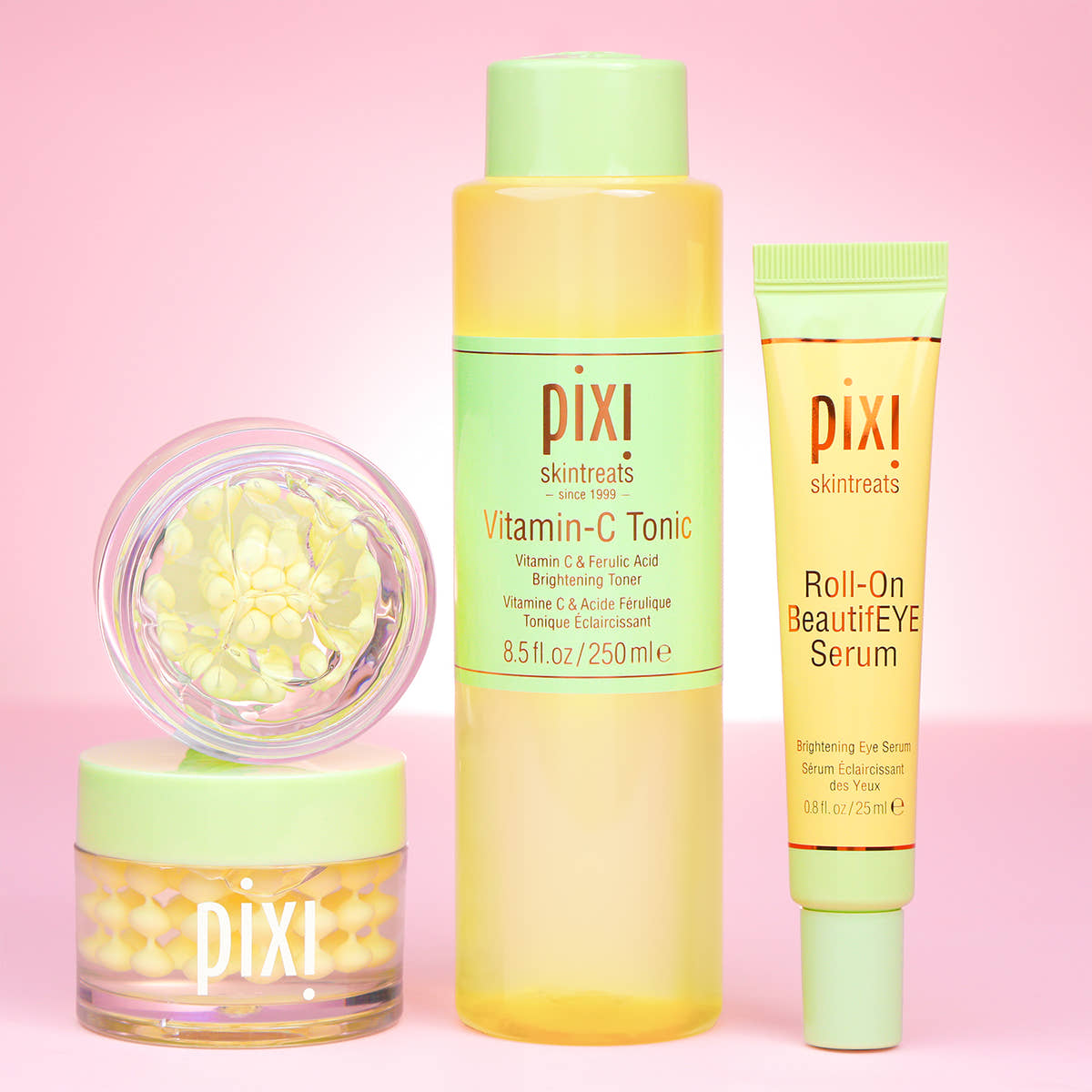 Pixi skincare products including Vitamin-C CreamSerum, Vitamin-C Tonic and Roll-on BeautifEYE Serum for eyes on a pink background