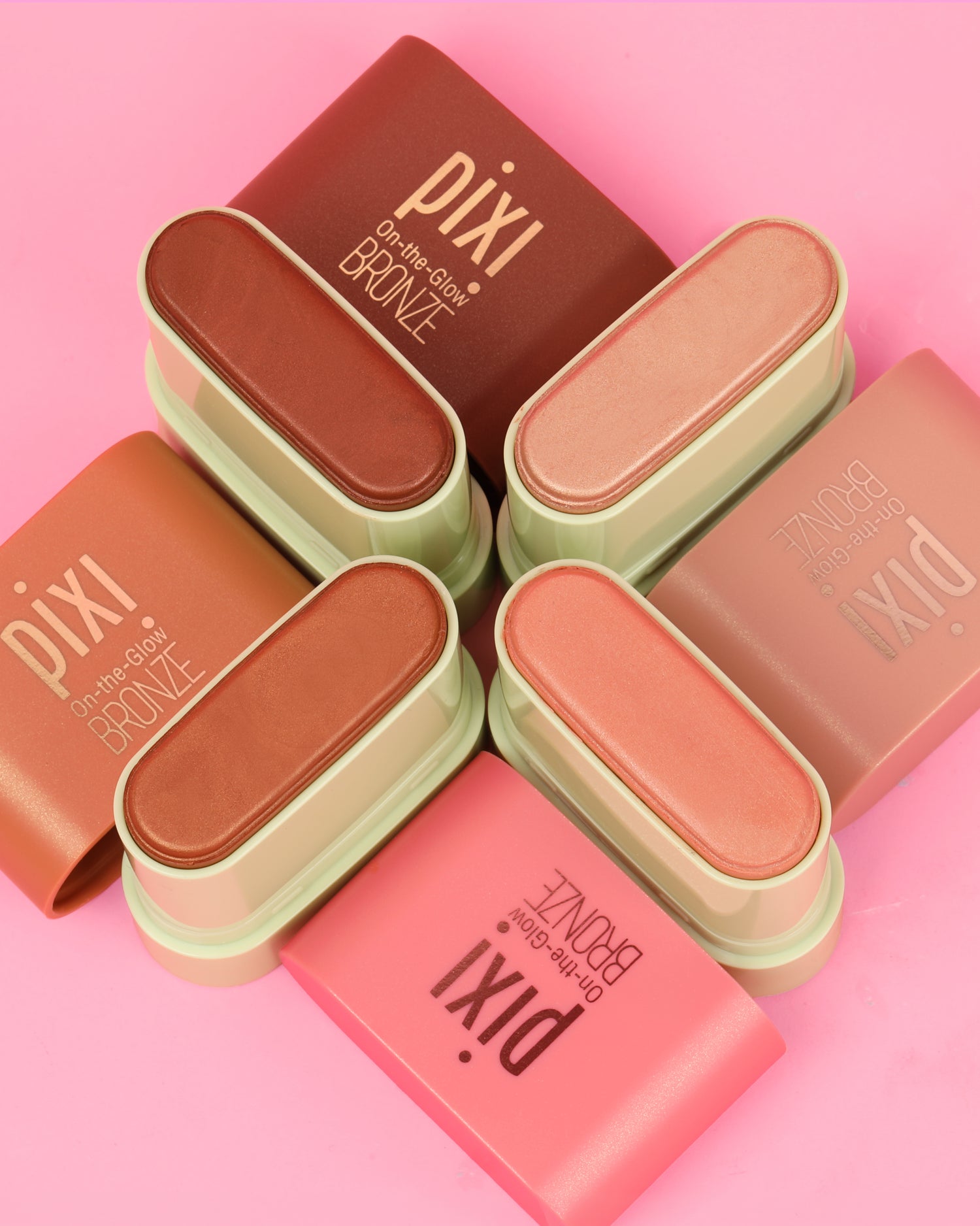 On-the-Glow BRONZE Petites in 4 shades shown on a pink background