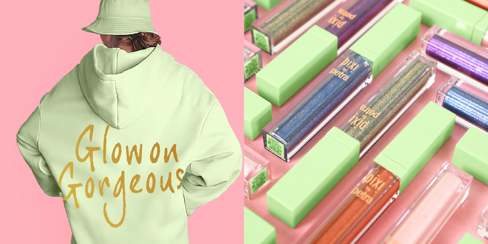 A split promotional image: on the left, a person from the back wears a pale yellow-green hoodie with large gold script text reading 'Glow on Gorgeous' against a pink background; on the right, several lip gloss tubes in matching pale green packaging are arranged on a pink surface.